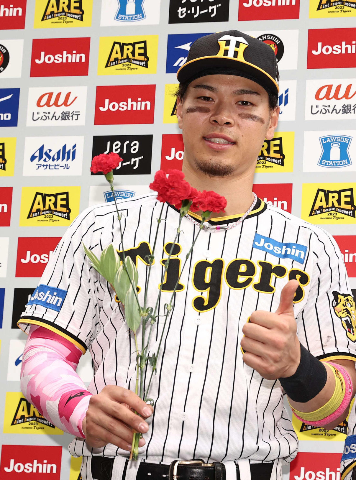 23年母の日にお立ち台でカーネーションを手にサムズアップポーズの佐藤輝