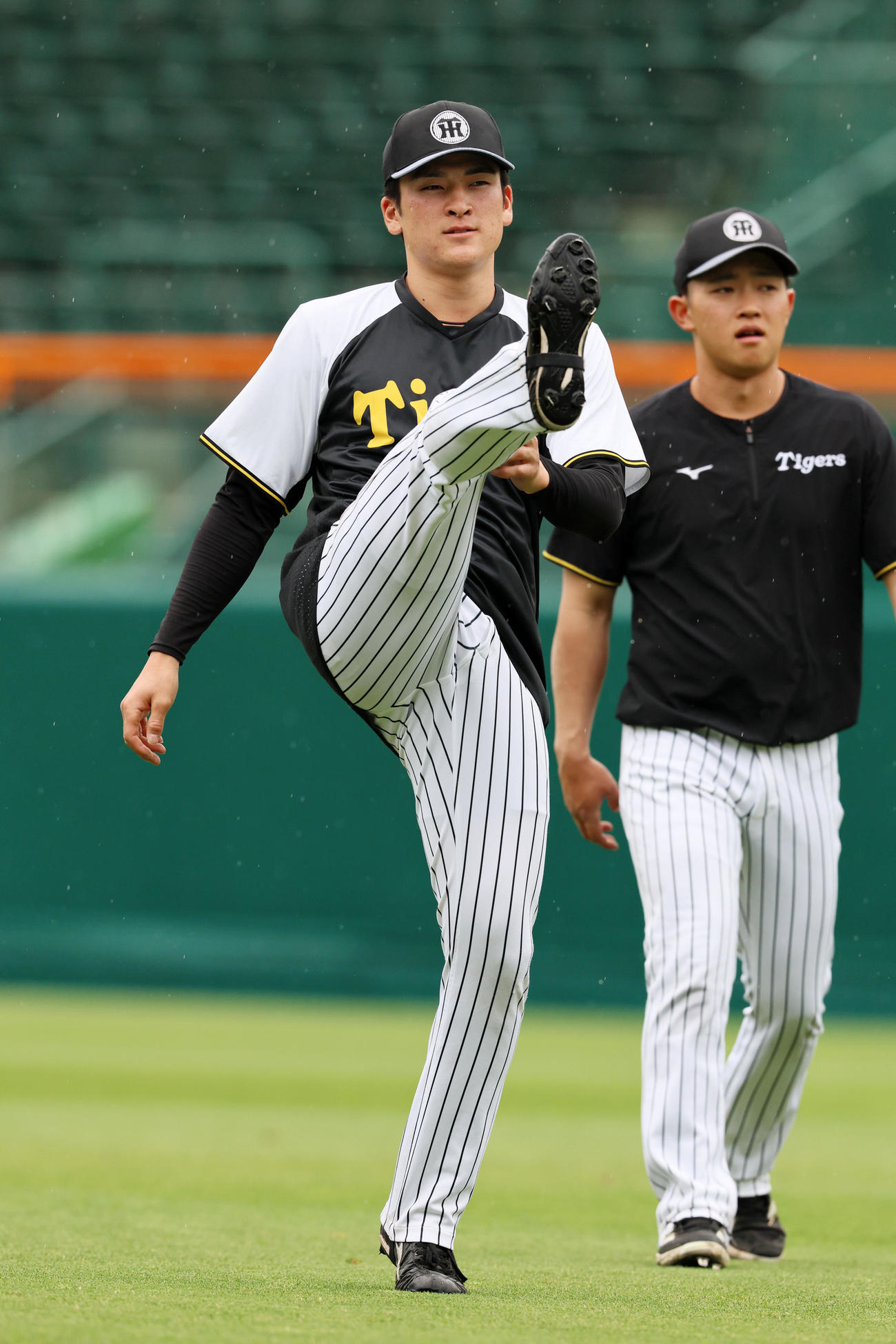 阪神対中日　外野でウオーミングアップする高寺。右は中川（撮影・加藤哉）