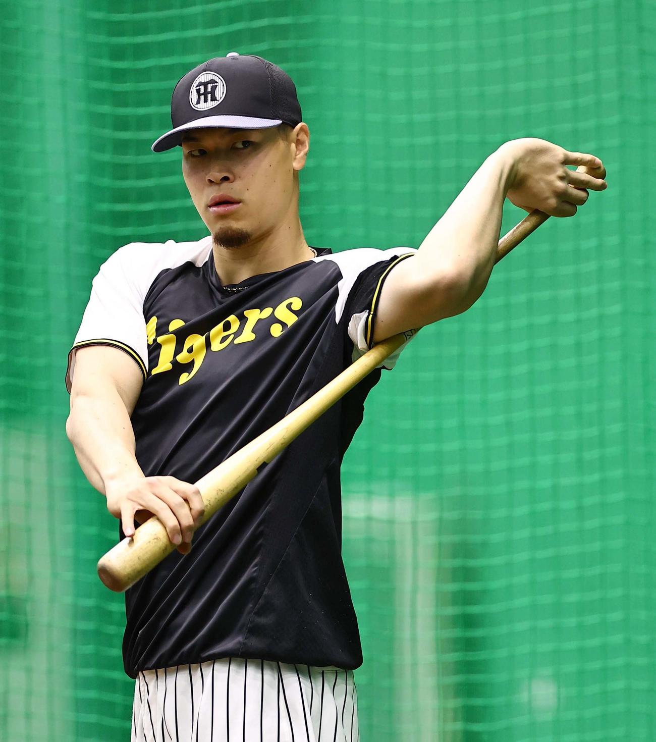 阪神対中日　バットを使ってストレッチをする佐藤輝（撮影・上田博志）