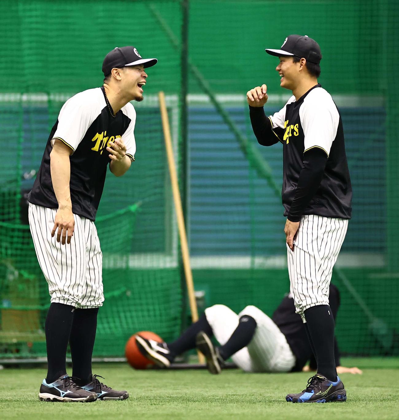 話が盛り上がり、爆笑する阪神佐藤輝（左）と森下（撮影・上田博志）