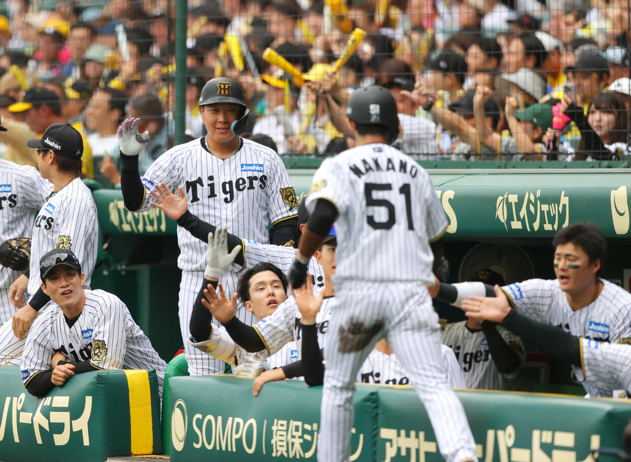 阪神対中日　1回裏阪神1死二塁、二走中野（手前）は、森下の中前適時打で生還しナインの祝福を受ける（撮影・上山淳一）