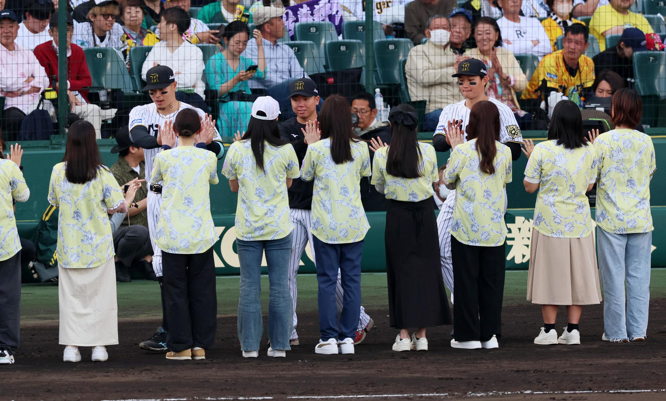 阪神対中日　中日に勝利し女性ファンとタッチする左から佐藤輝、村上、森下（撮影・加藤哉）