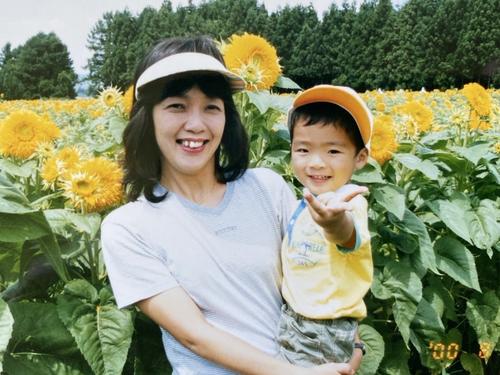 ひまわりをバックに笑顔の日本ハム郡司（右）と母純子さん（本人提供）