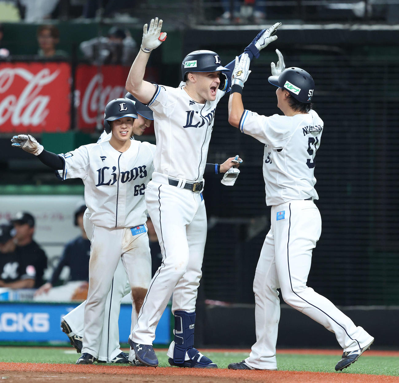 西武対ロッテ　3回裏西武1死満塁、左越え先制満塁本塁打で生還し、西川（右）らナインに迎えられるネビン（撮影・河田真司）