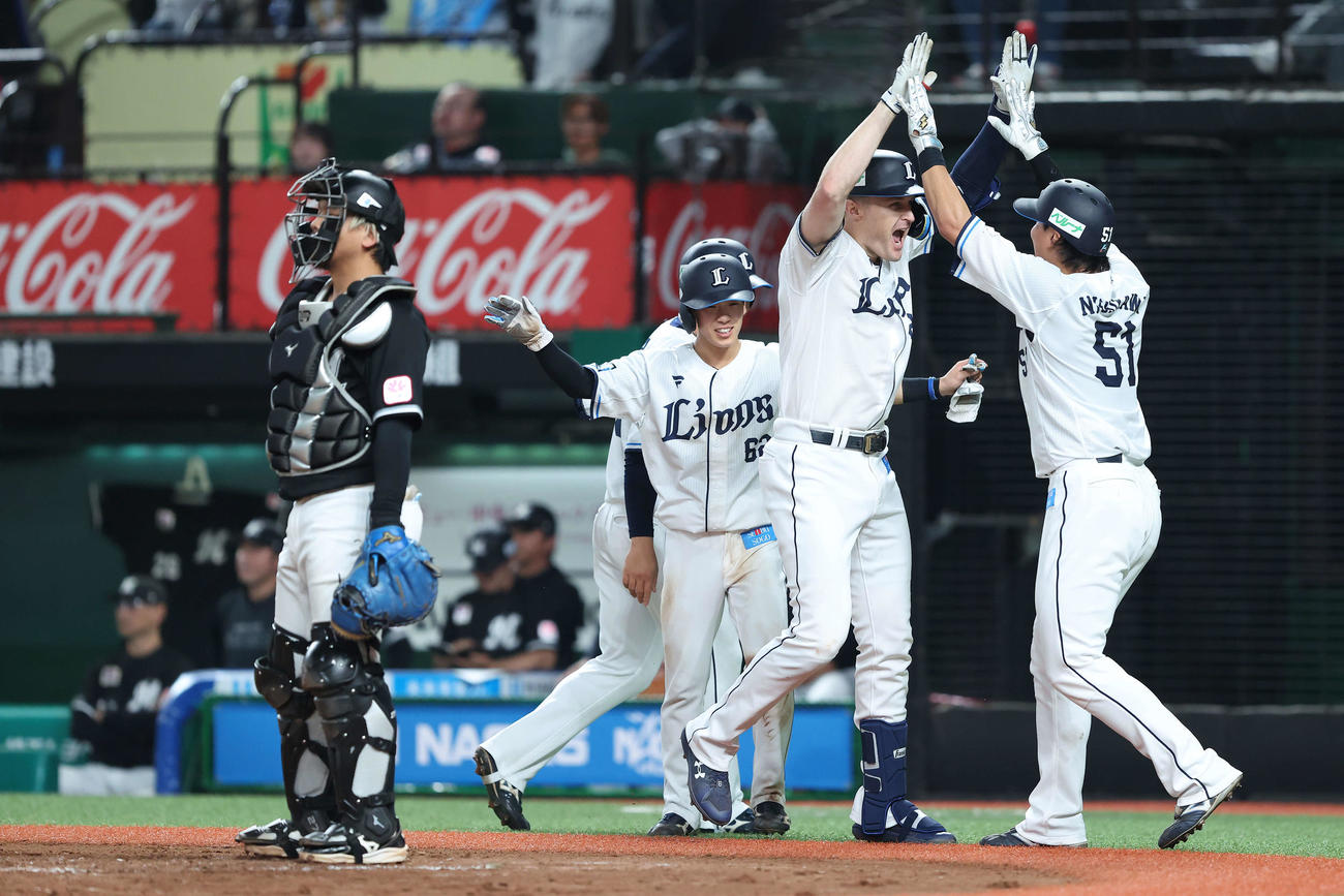 西武対ロッテ　3回裏西武1死満塁、左越え先制満塁本塁打で生還し、西川（右）らナインに迎えられるネビン（右から2人目）（撮影・河田真司）