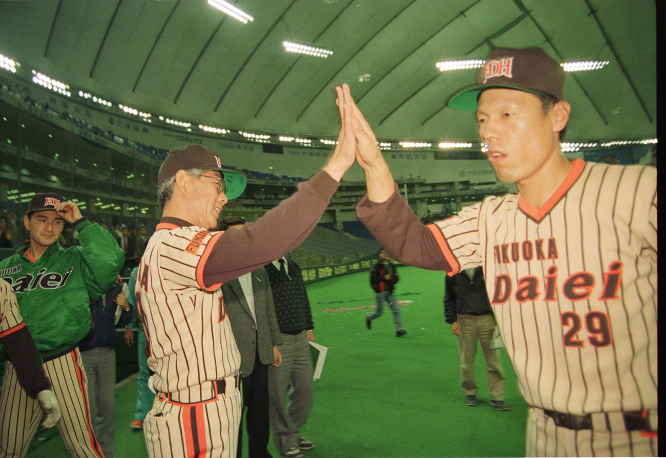 ダイエー球団初勝利を挙げ、ハイタッチを交わす杉浦忠監督と山本和範。左は勝ち投手の加藤伸一（1989年4月10日撮影）