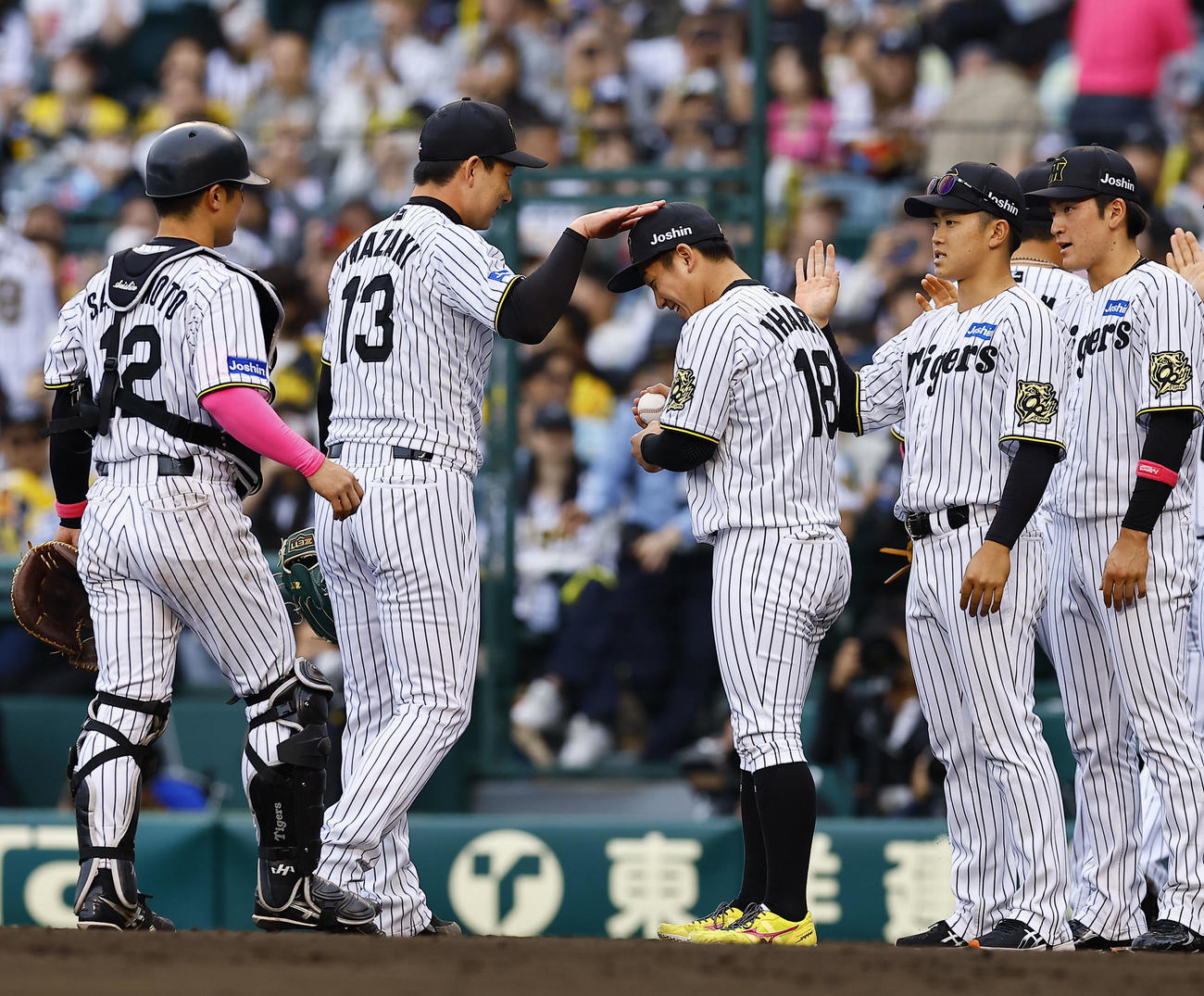 阪神対中日　2勝目を飾り、岩崎からウイニングボールを受け取り、頭をポンとされる阪神伊原（中央右）（撮影・藤尾明華）