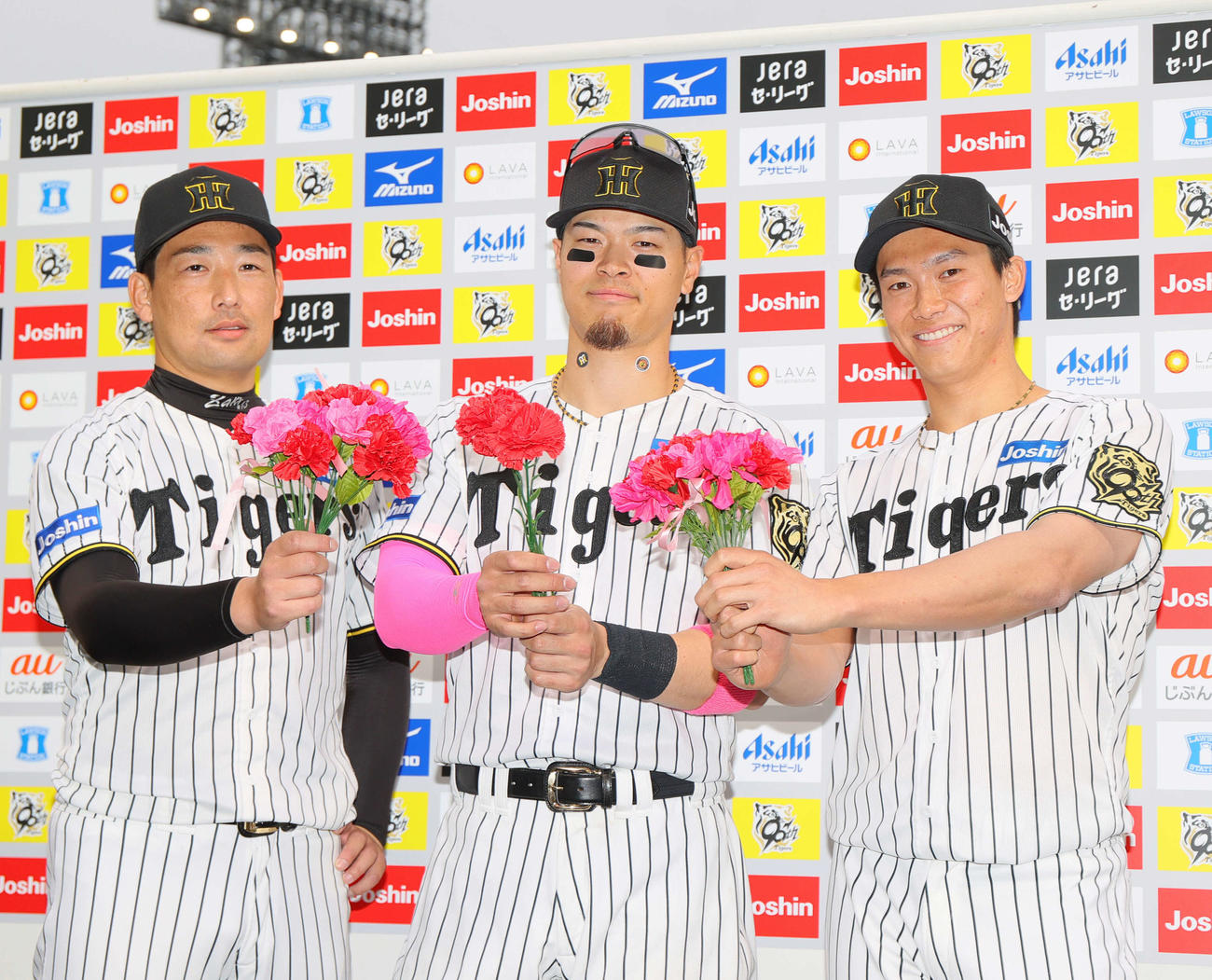 阪神対中日　カーネーションを手に笑顔を見せる、左から岩崎、佐藤輝、湯浅（撮影・上山淳一）