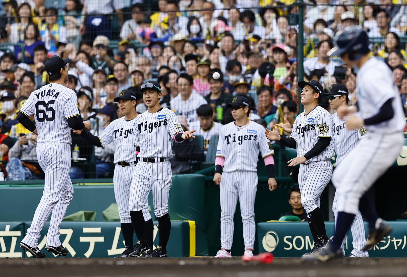 阪神対中日　6回のピンチを抑えた2番手湯浅（左）を出迎える阪神伊原（右から3人目）（撮影・藤尾明華）
