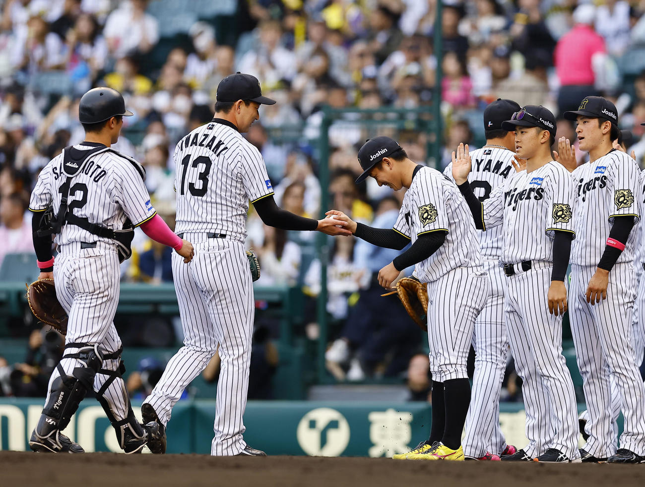 阪神対中日　2勝目を飾り、及川らとタッチを交わす阪神伊原（右から2人目）（撮影・藤尾明華）