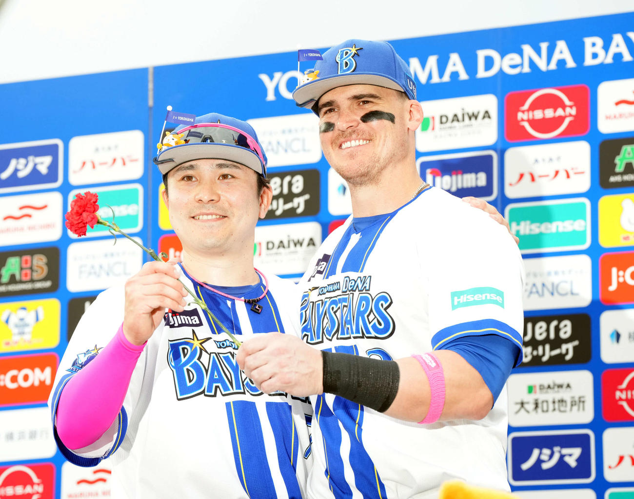 DeNA対広島　広島に勝利カーネーションを手に笑顔を見せるDeNA佐野（左）とオースティン（撮影・たえ見朱実）