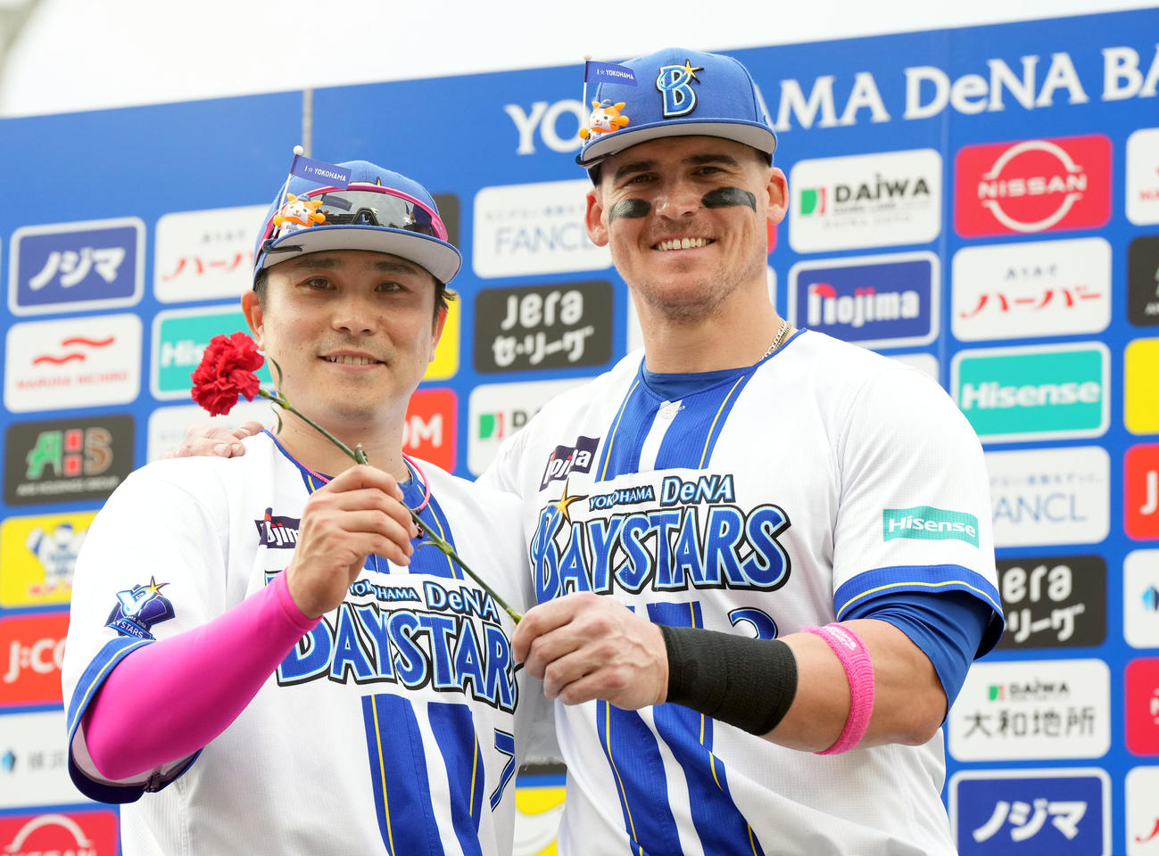 DeNA対広島　広島に勝利カーネーションを手に笑顔を見せるDeNA佐野（左）とオースティン（撮影・たえ見朱実）