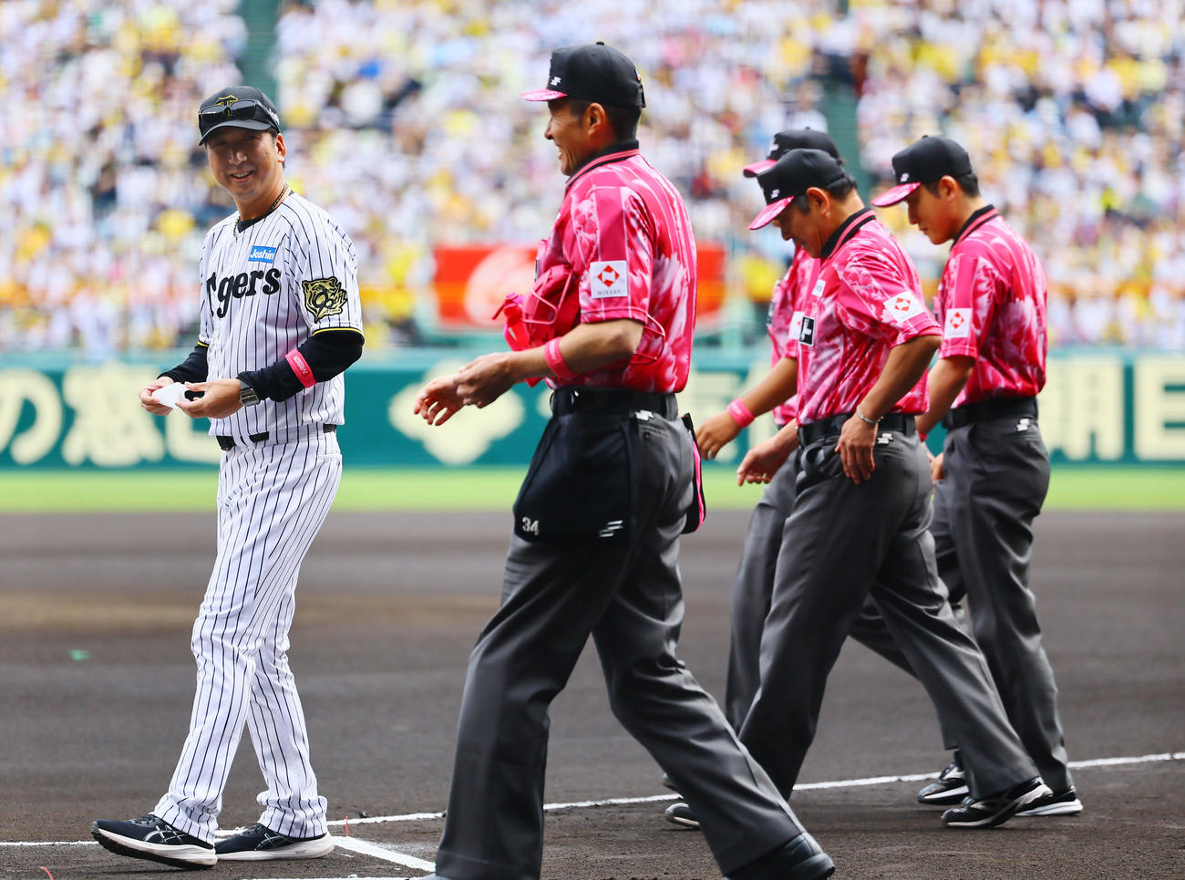 阪神対中日　ピンクの制服を着た審判と笑顔で言葉を交わす阪神藤川監督（撮影・藤尾明華）