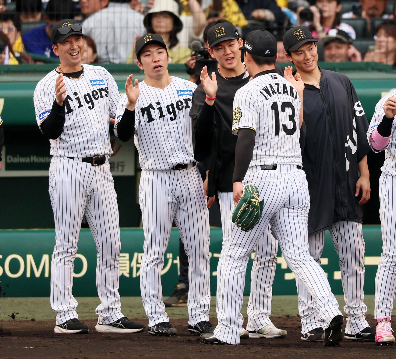 阪神対中日　中日に勝利し岩崎（右）らナインをタッチで迎える藤川監督。左から2人目は石井、3人目は及川、ひとりおいて湯浅（撮影・加藤哉）