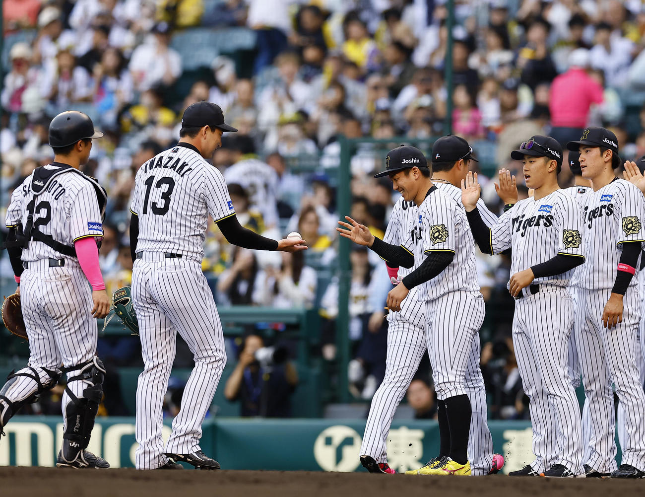 阪神対中日　2勝目を飾り、及川らとタッチを交わす阪神伊原（右から2人目）（撮影・藤尾明華）