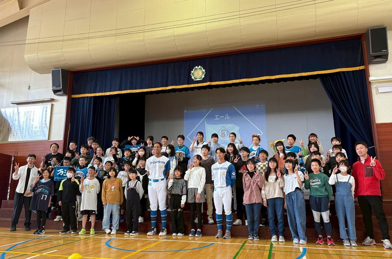 北広島双葉小の児童と写真撮影する日本ハム万波（前列66番）と細川（同56番）（撮影・永野高輔）
