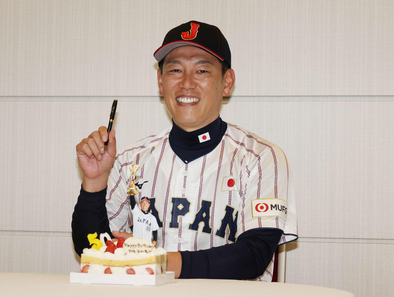 50歳の誕生日をお祝いされ笑顔でプレゼントのペンを持つ、侍ジャパン井端監督（撮影・増田悦実）