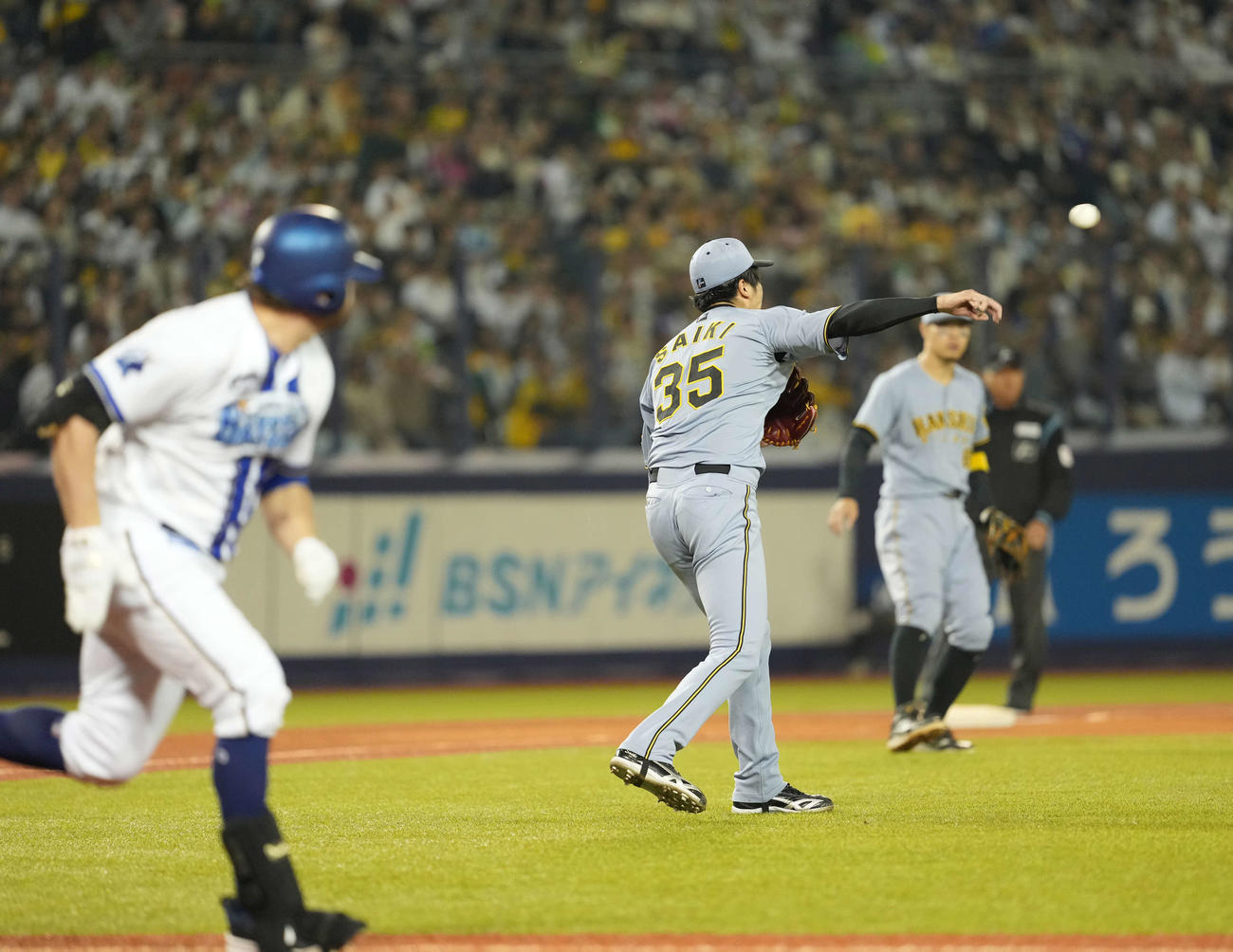 DeNA対阪神　5回裏DeNA無死一塁、二塁に悪送球する才木（撮影・井上学)