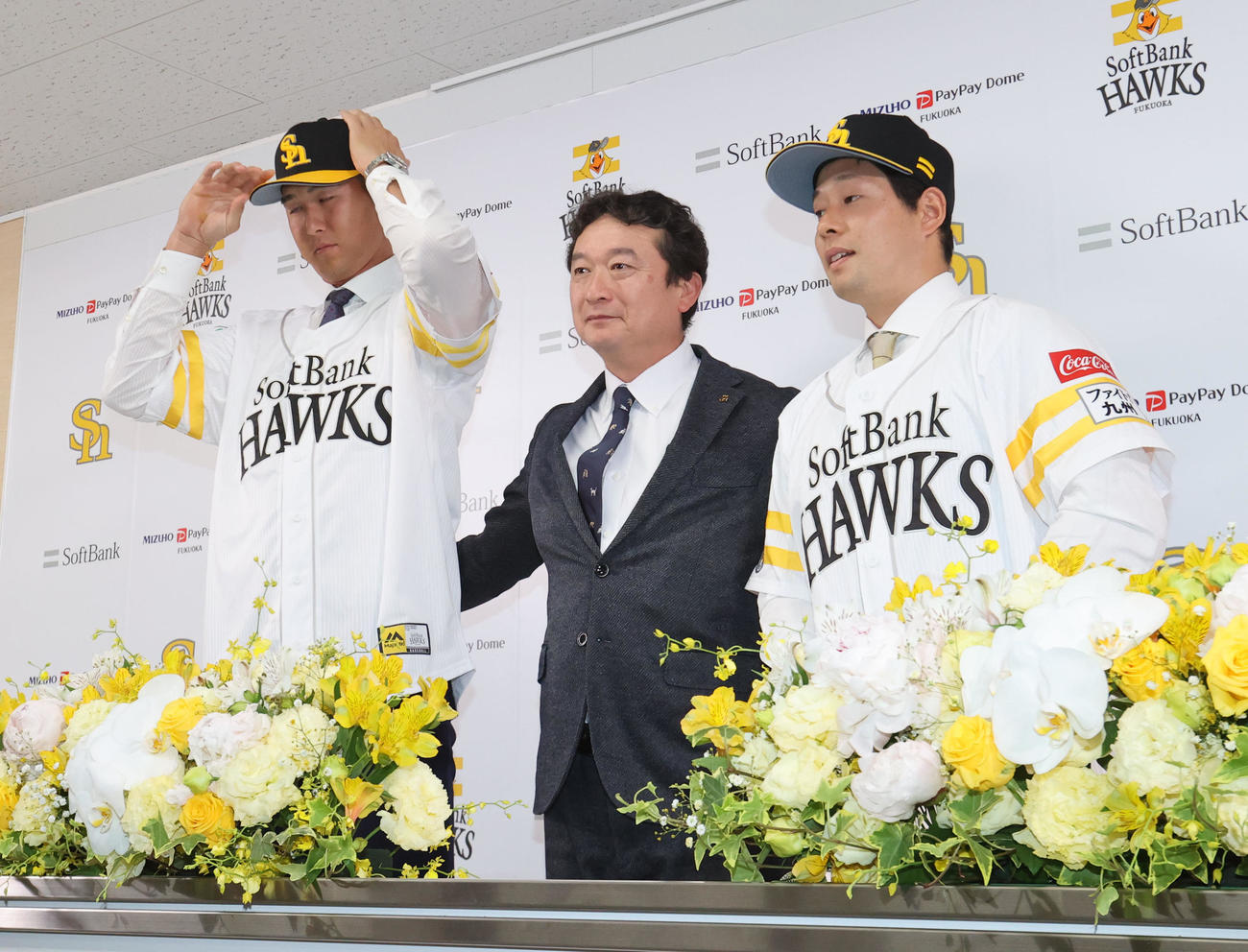 入団会見でユニホーム姿を披露する秋広と大江（左）、中央は三笠GM（撮影・梅根麻紀）