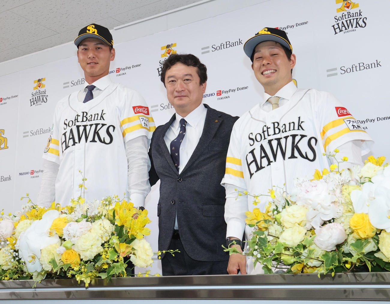 入団会見でユニホーム姿を披露する秋広（左）と大江、中央は三笠GM（撮影・梅根麻紀）