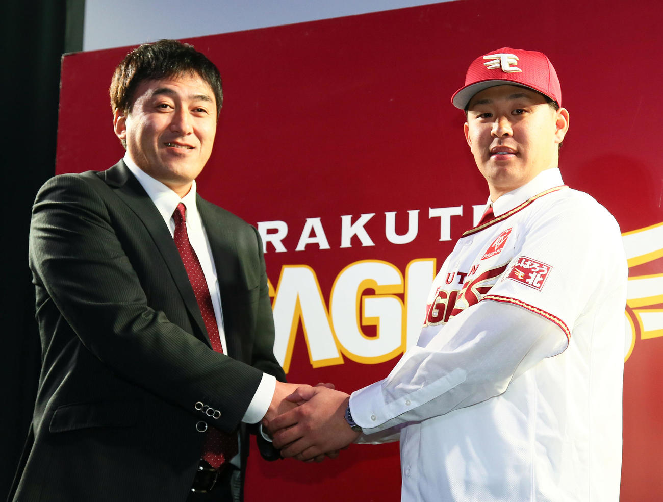 2018年12月1日、楽天への入団会見で握手を交わす浅村（右）と石井GM