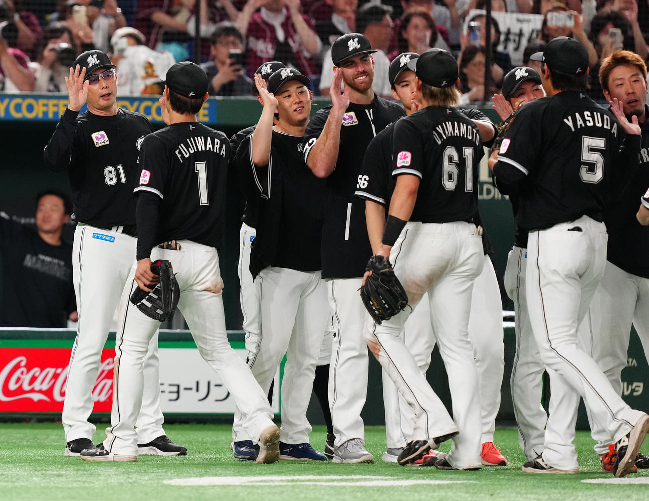 楽天対ロッテ　試合後、ロッテの選手たちとタッチを交わす吉井監督（左端）（撮影・江口和貴）