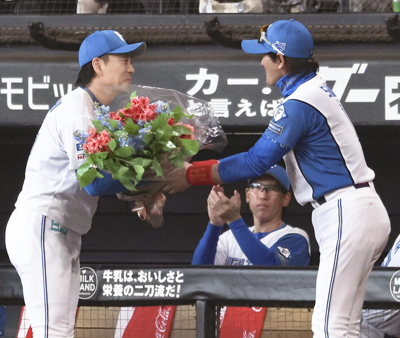 連続救援登板のプロ野球記録を塗り替え、新庄監督（右）から花束を贈られる日本ハム宮西（共同）
