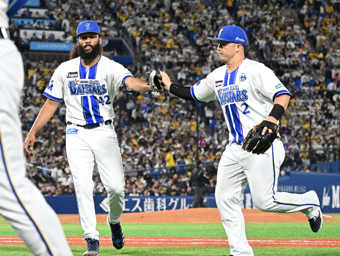 DeNA対阪神　4回表阪神2死一、二塁、一打先制のピンチを逃げ切り好守備を見せた二塁手牧とタッチでベンチに戻るDeNAジャクソン（撮影・千葉一成）