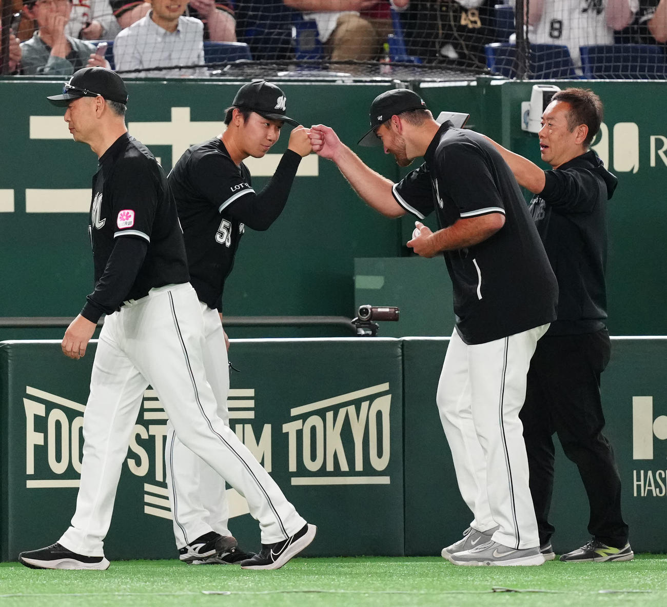 楽天対ロッテ　試合後、タッチを交わすロッテ木村（中央左）とサモンズ（同右）。左端は吉井監督（撮影・江口和貴）