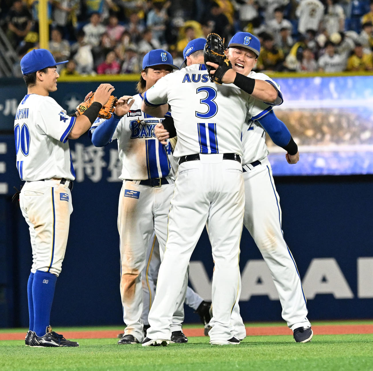 阪神に勝利し、オースティンと抱き合って喜ぶ牧（右）らDeNAナイン（撮影・千葉一成）