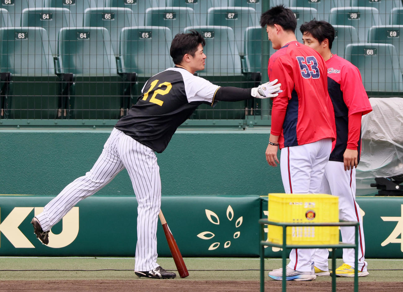 阪神対広島　阪神の練習中、坂本（左）に頭を下げに来た岡本と右は石原の広島バッテリー（撮影・加藤哉）
