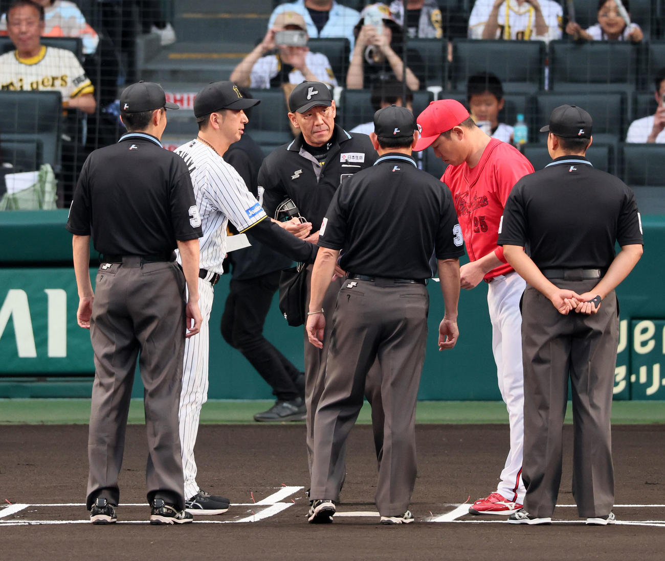 阪神対広島　メンバー表の最終確認で握手する阪神藤川監督（左）と広島新井監督（撮影・加藤哉）