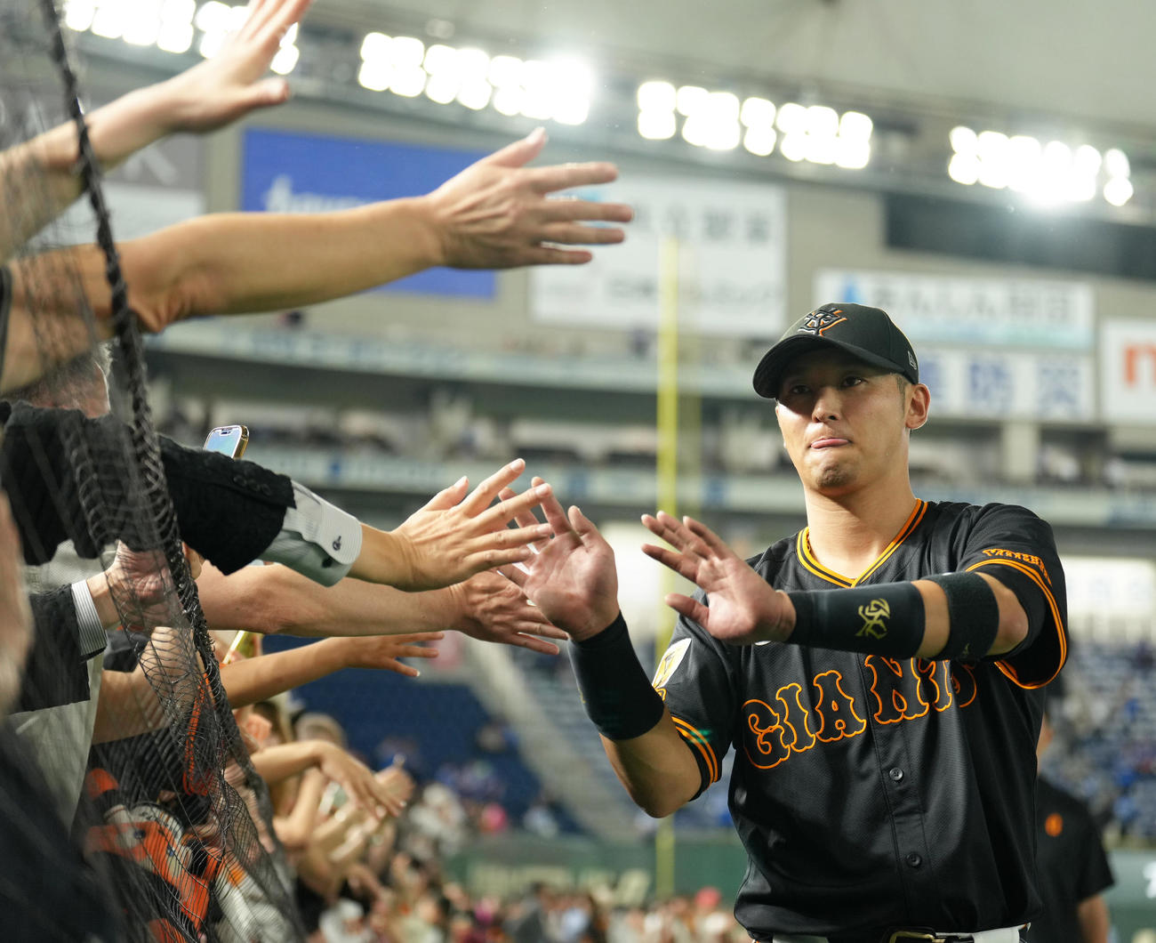 巨人対中日　逆転3点本塁打の吉川は大勢のファンとタッチを交わす（撮影・足立雅史）