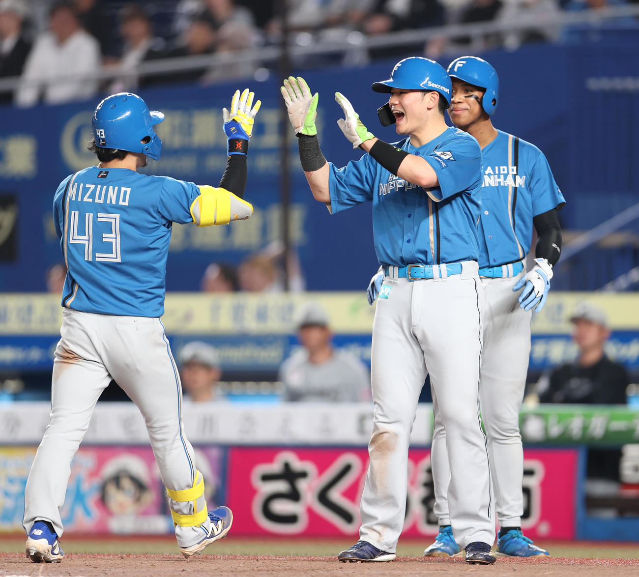 ロッテ対日本ハム　7回表日本ハム2死一、二塁、右翼越え3点本塁打を放った水野を出迎える清宮幸（中央）。右は万波（撮影・水谷安孝）