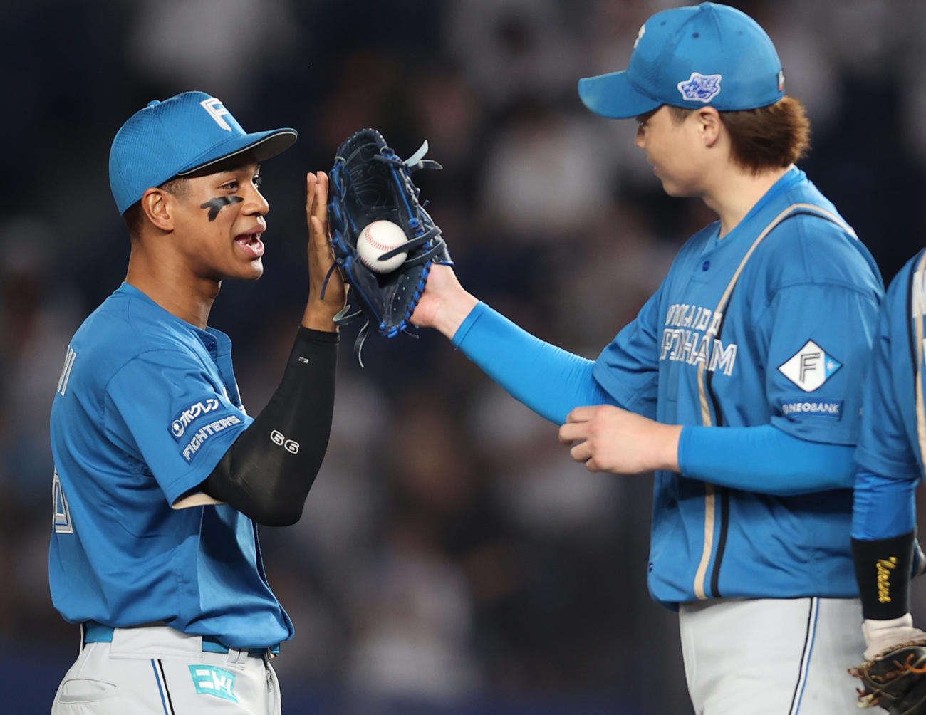 ロッテ対日本ハム　完封勝利を納め万波（左）ハイタッチする山崎（撮影・水谷安孝）