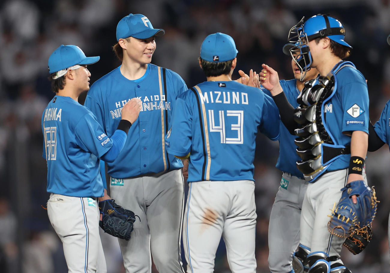 日本ハム　完封勝利を納めナインをマウンドで出迎える山崎福（左から2人目）（撮影・水谷安孝）