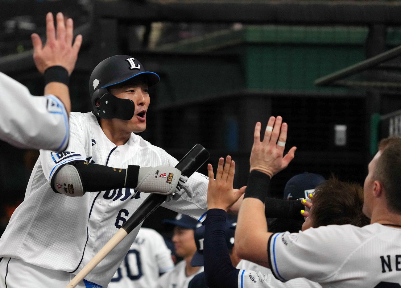 西武対オリックス　2回裏西武1死満塁、先制犠飛を放ち、ネビン（右）らとタッチを交わす源田（撮影・狩俣裕三）