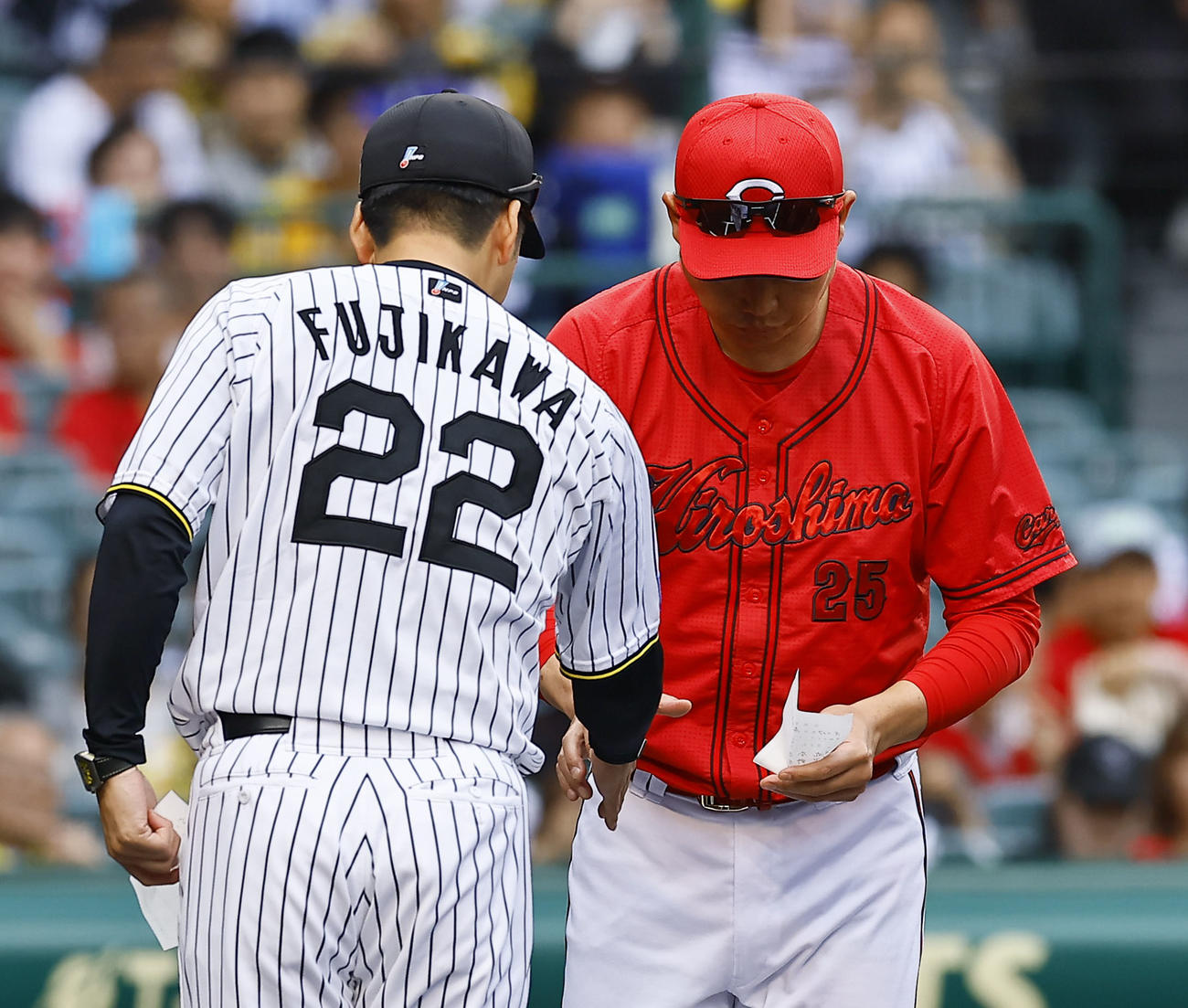 阪神対広島　メンバー表交換を行う阪神藤川監督（左）と広島新井監督（撮影・藤尾明華）