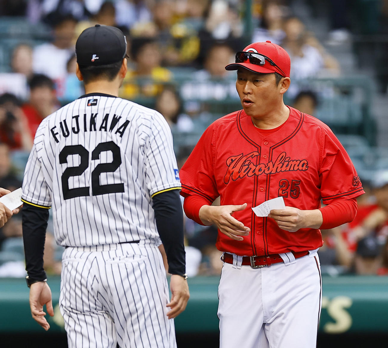 阪神対広島　メンバー表交換を行う阪神藤川監督（左）と広島新井監督（撮影・藤尾明華）