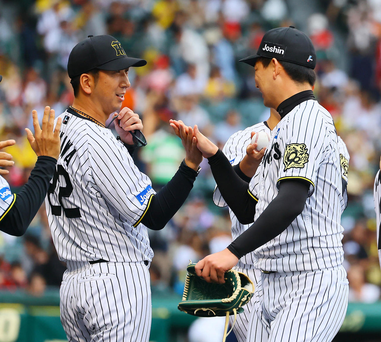 阪神対広島　通算100セーブを上げた岩崎とタッチを交わす阪神藤川監督（撮影・藤尾明華）