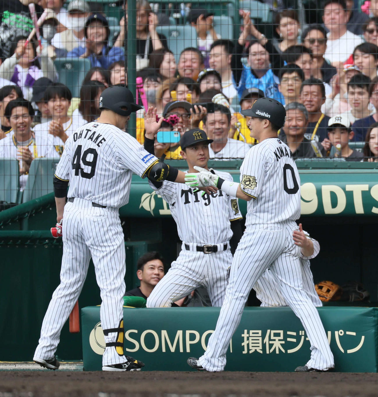 阪神対広島　4回裏阪神攻撃終了、先制適時打を放った木浪（右）は打席を終えた大竹とタッチする（撮影・宮崎幸一）