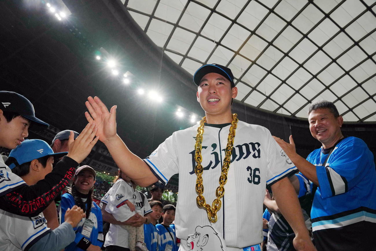 西武対オリックス　ヒーローインタビュー後、ファンとタッチを交わすプロ初勝利の山田（撮影・狩俣裕三）