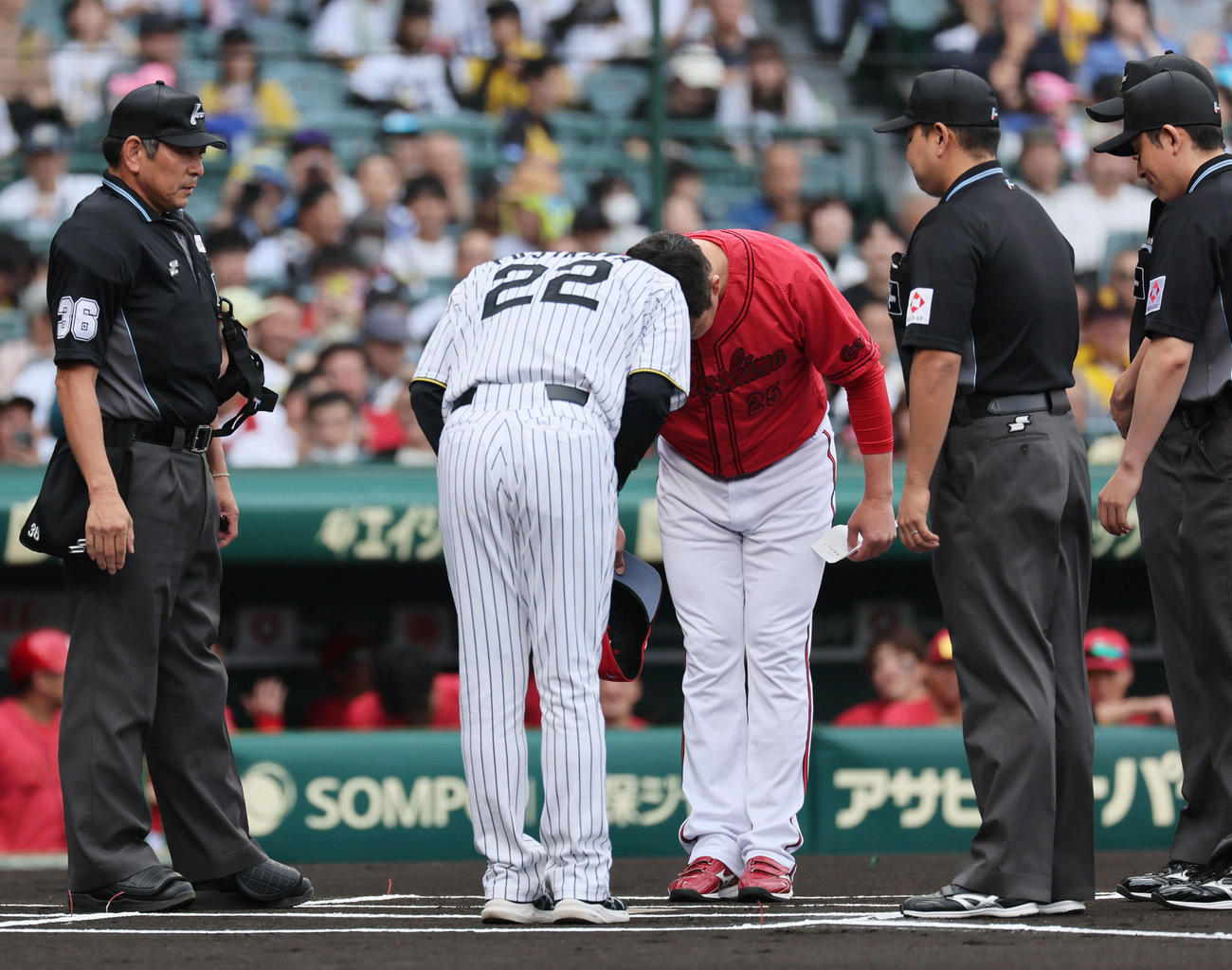 阪神対広島　メンバー確認で目を合わせ、あいさつと握手を交わした阪神藤川監督（左）と広島新井監督（撮影・宮崎幸一）