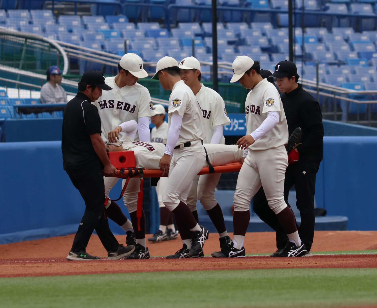 早大対明大　5回裏明大2死一塁、中飛を追った左翼手寺尾は中堅手尾瀬と激突し担架で搬送される（撮影・寺本吏輝）