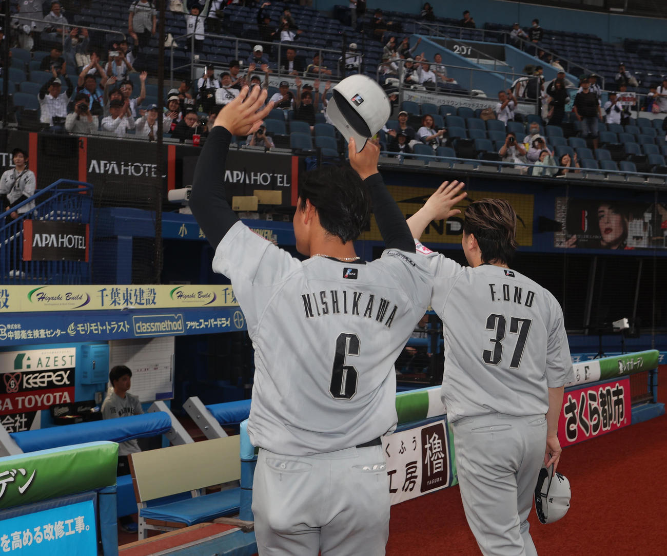 ロッテ対日本ハム　12回サヨナラ勝利しファンに手を振る西川（左）と小野（撮影・水谷安孝）