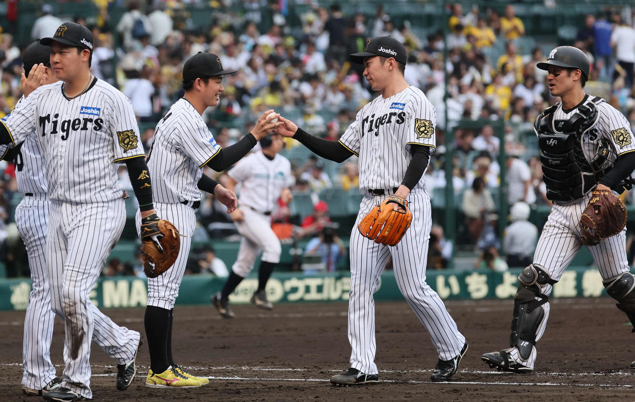 阪神対広島　伊原（中央左）は最後を締めた石井から勝利球を受け取る（撮影・宮崎幸一）