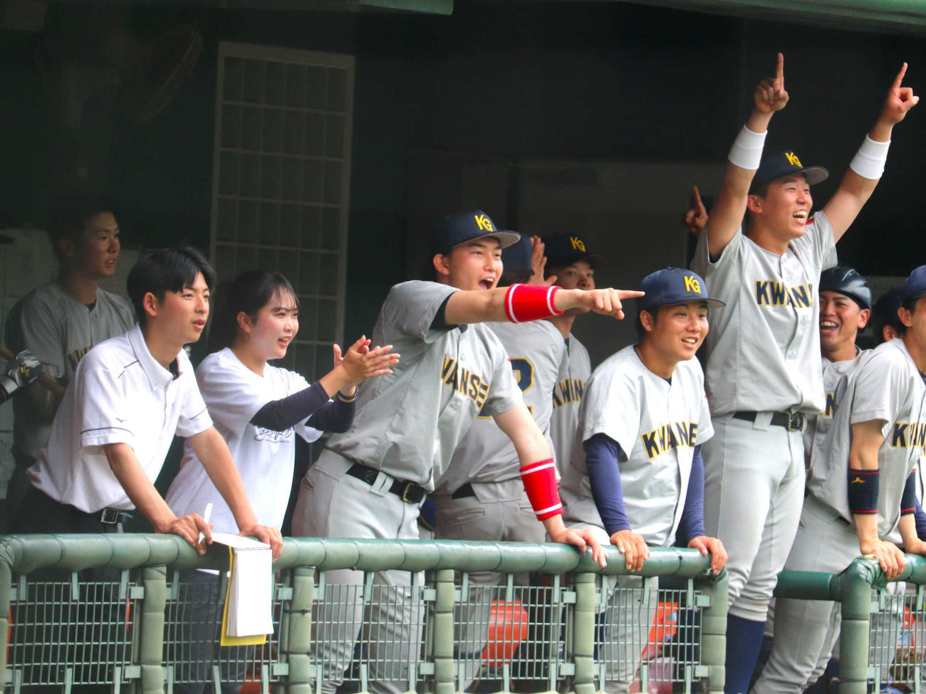 関西学生春季第6節2回戦　近大対関学大　ナインとともにベンチで笑顔を見せる、広島新井貴浩監督長男、関学大・新井（撮影・中島麗）