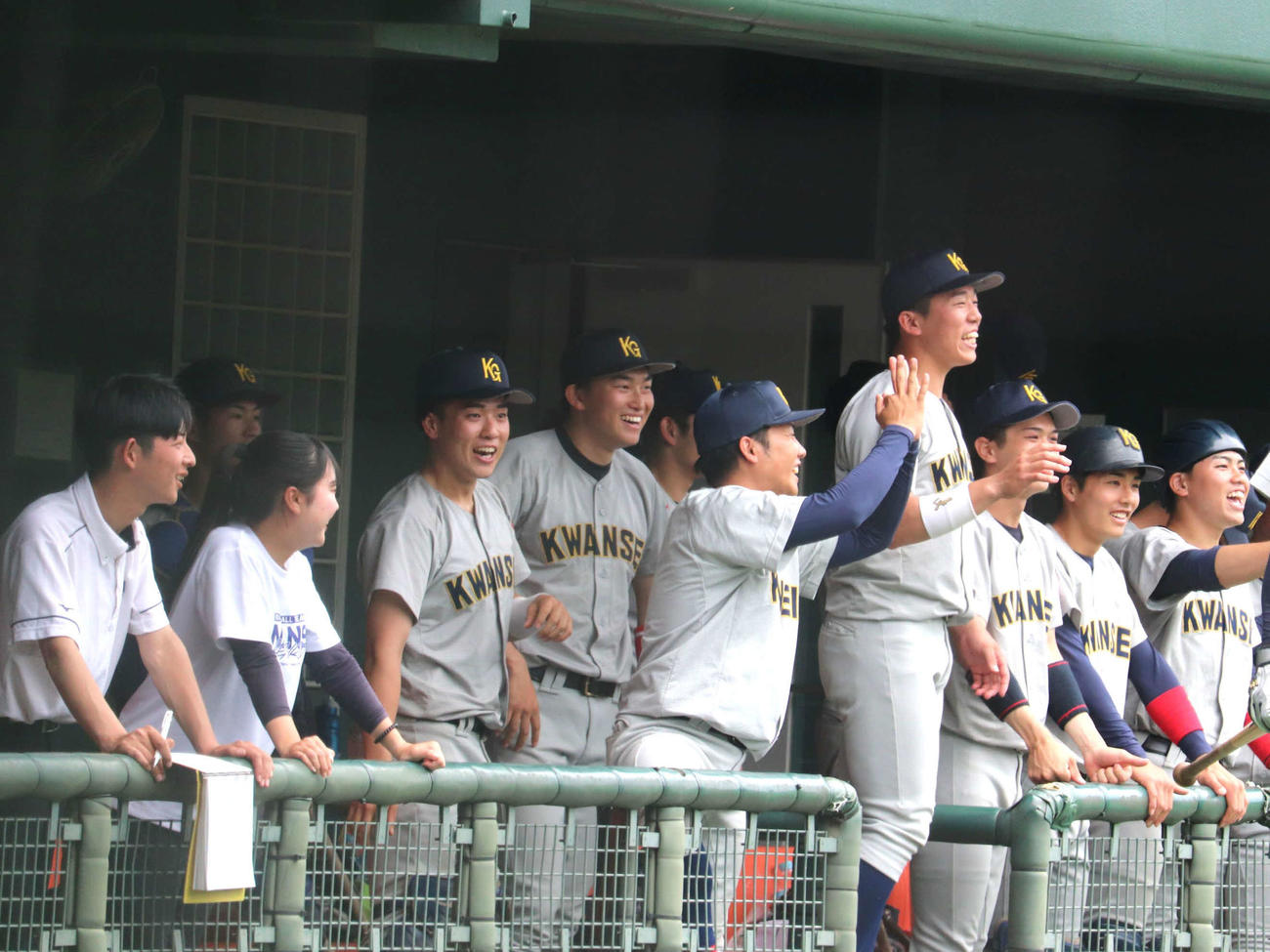 関西学生春季第6節2回戦　近大対関学大　ナインとともにベンチで笑顔を見せる、広島新井貴浩監督長男、関学大・新井（撮影・中島麗）