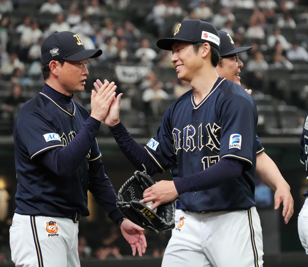 西武対オリックス　プロ初完投勝利を挙げ、オリックス岸田監督（左）とタッチを交わす先発曽谷（撮影・狩俣裕三）