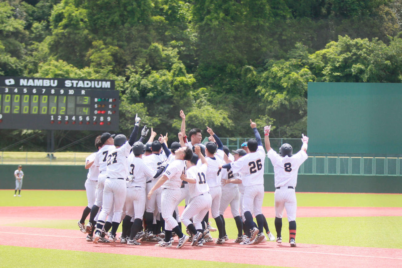 グラウンドで優勝の喜びを分かち合う東日本国際大サイン（撮影・高橋香奈）